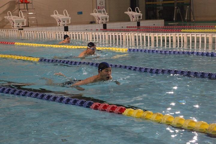 刘力平老师(前)在男子D组100米蛙泳比赛中